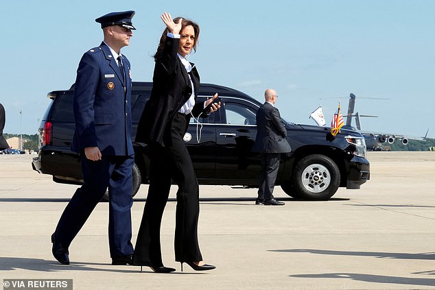 Harris waves to waiting reporters and photographers as she makes her way to the Air Force Two Steps