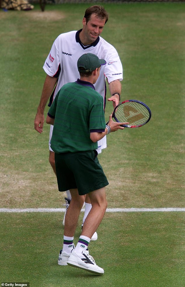 Greg Rusedski hands his racket to a ball boy during his match against Goran Ivanisevic in 2001