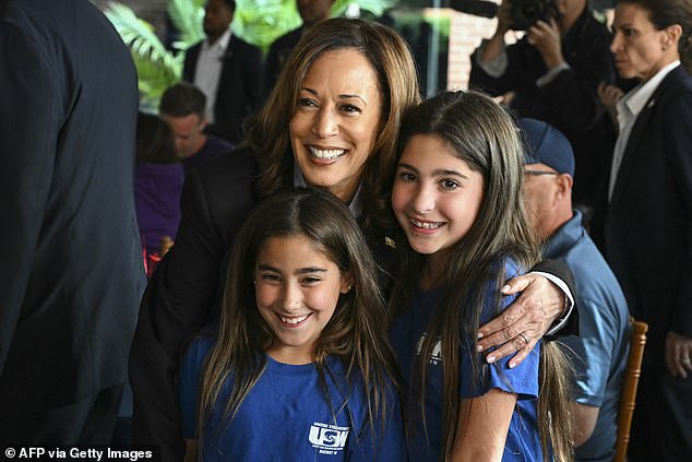 Kamala Harris poses for a photo with the daughters of a union member while campaigning with President Joe Biden at the union hall of IBEW Local Union #5 in Pittsburgh