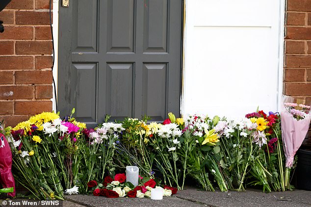 Tributes were left outside the Oldbury home on Friday (pictured: flowers and candles on the pavement)