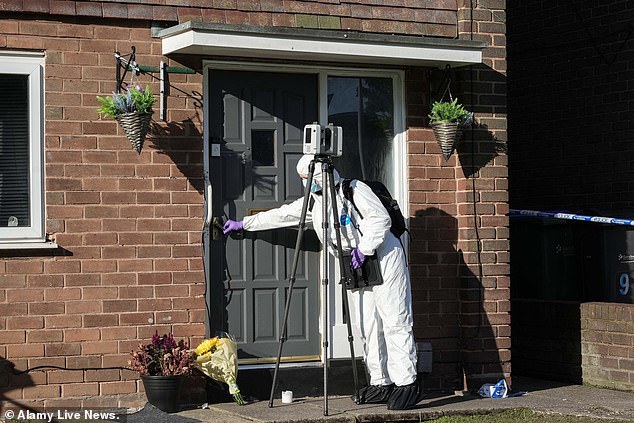 Forensic officers searched the building on Friday (pictured: a crime scene officer with a 3D imaging device)