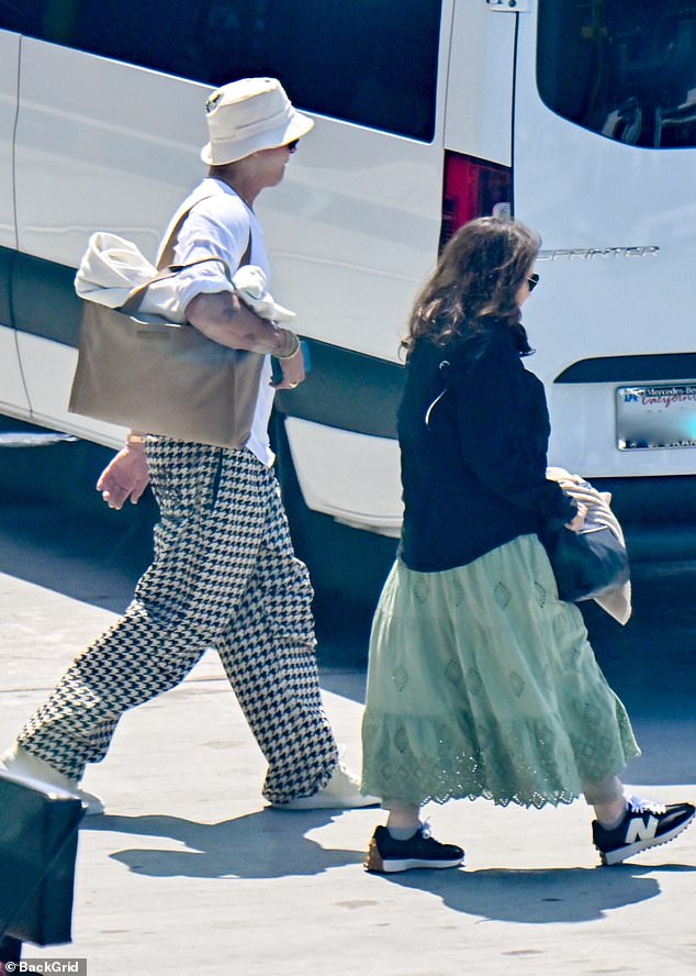 The 60-year-old Hollywood actor wore baggy houndstooth pants, paired with a white bucket hat and a brown bag, as he walked to his car after his long journey home.