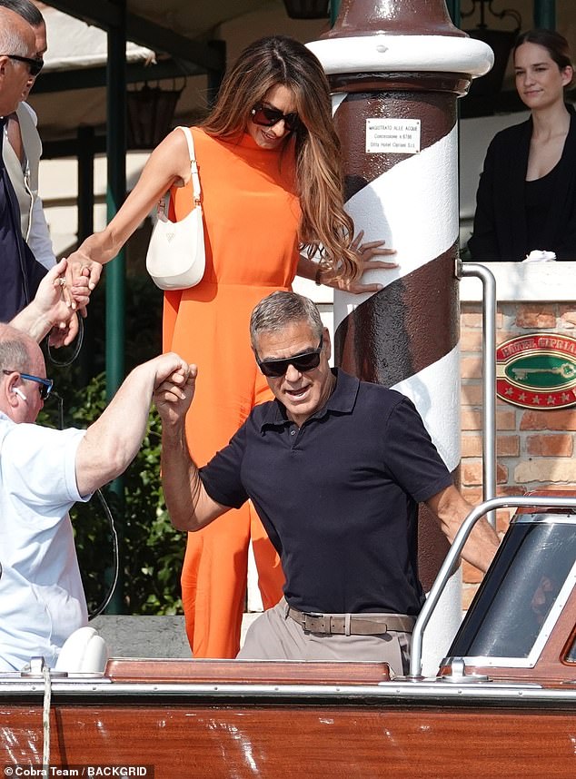 The 46-year-old international human rights lawyer exuded glamour in an orange jumpsuit as she was spotted boarding a river taxi with George Clooney, 63