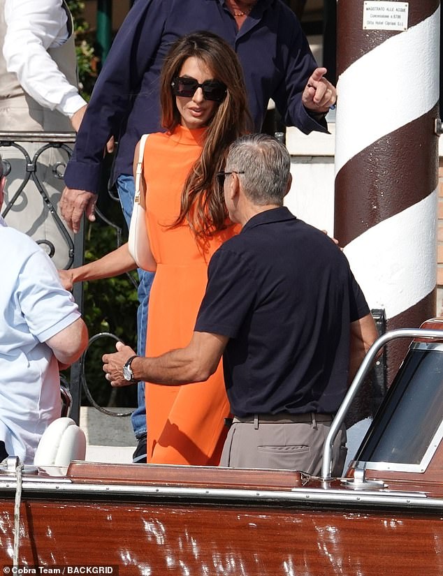 Amal completed her look with oversized sunglasses and styled her glossy chestnut locks in a side parting