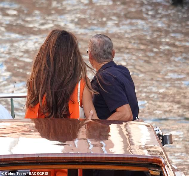 The couple stood arm in arm as they looked out over the beautiful view of the city