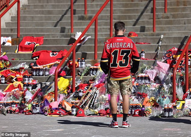 A fan visits the memorial while wearing Gaudreau's No. 13 jersey for the Flames last week