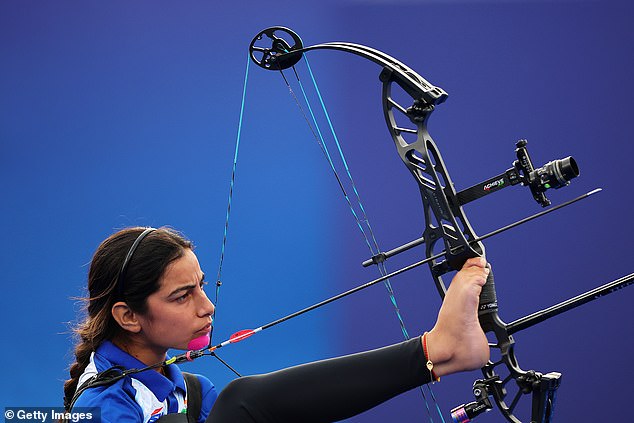 First she lifts the arrow into place with her right foot, then she lifts the bow, which was balanced on her left knee, with the same foot.