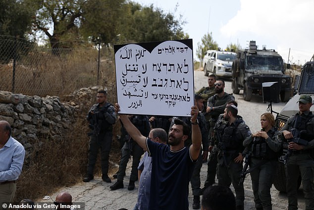 A group of activists holding banners hold a protest in the Makhror area against the forced displacement of Palestinians and the demolition of their homes by Israeli forces on September 3, 2024.