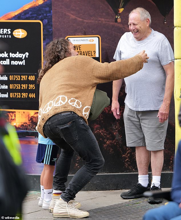 The TV star leaned over to take a selfie with a fan, while another man looked on and smiled