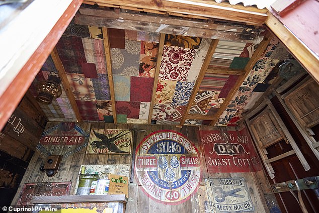 The walls are decorated with brightly colored vintage plates, while the ceiling looks like a patchwork of patterned paper