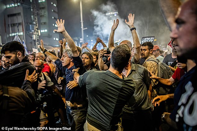 Israeli protesters are pushed back by plainclothes police officers during a demonstration in front of the Ministry of Defense last night.