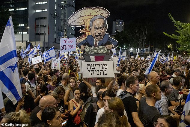 An Israeli protester carries a poster reading 