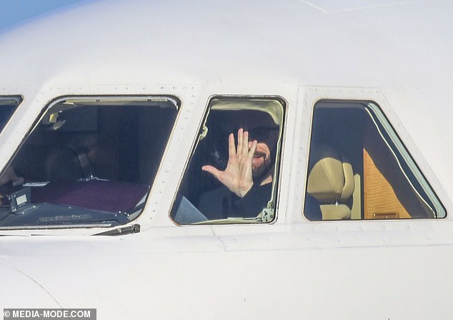 Travolta, 70, hid his famous face behind designer sunglasses as he waved to fans from the plane