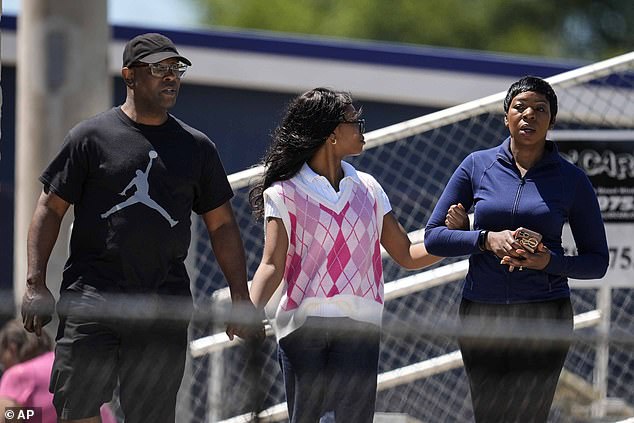 Parents escort their child from Apalachee High School after a shooting at the school on Wednesday