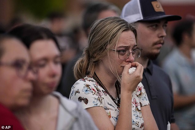 Relatives pray during a candlelight vigil for the slain students and teachers of Apalachee High School