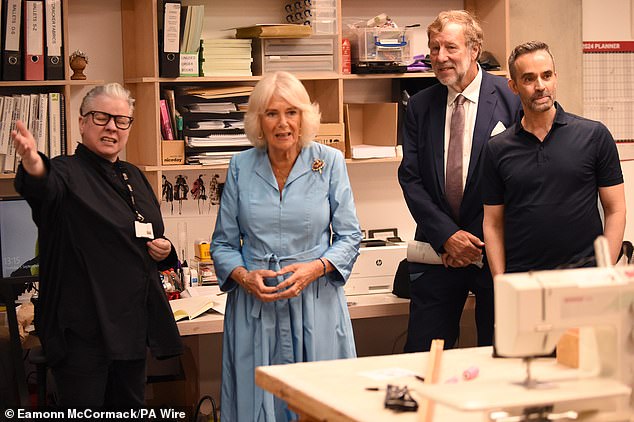 Queen Camilla paired her powder blue shirt dress with a gold and red brooch and wore what appeared to be a friendship bracelet on her left wrist