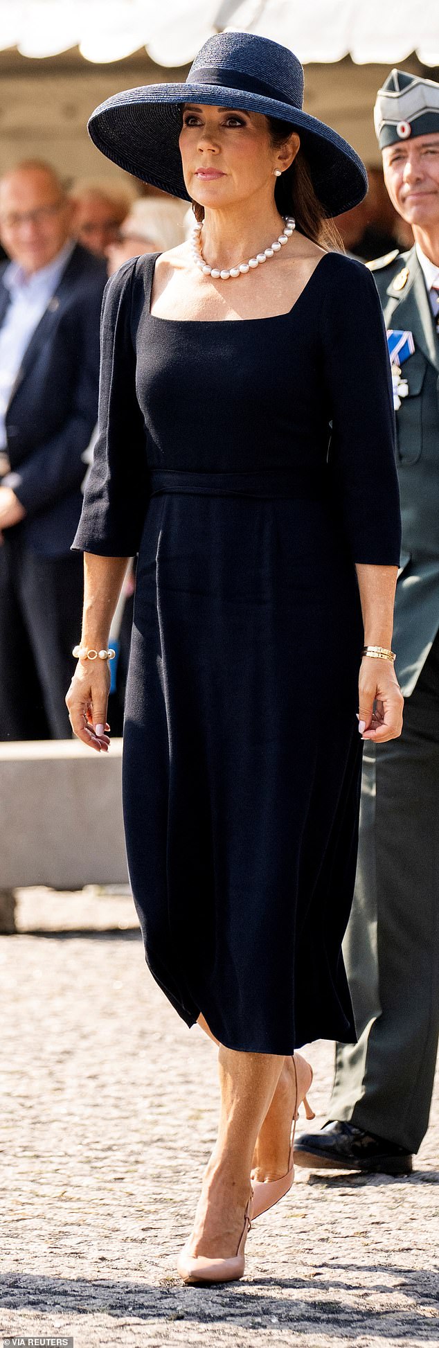 Mary wore a simple yet chic black dress with a square neckline and quarter length puff sleeves and wore pink strappy heels