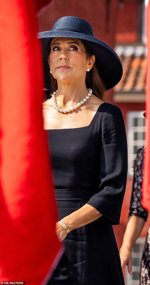 The Queen wore her glistening brunette locks loose in a sleek, straight blow-dry and opted for smokey eyeshadow and pink lipstick