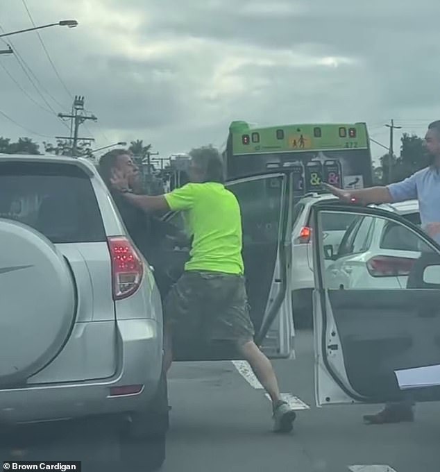 At one point, the man in the safety goggles held the other man against the four-wheel drive before several bystanders intervened (photo)