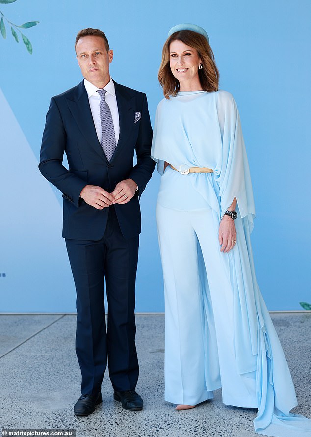 Natalie slipped into a flowing blue chiffon cape which she draped over a matching jumpsuit while cinching her waist with a beige belt