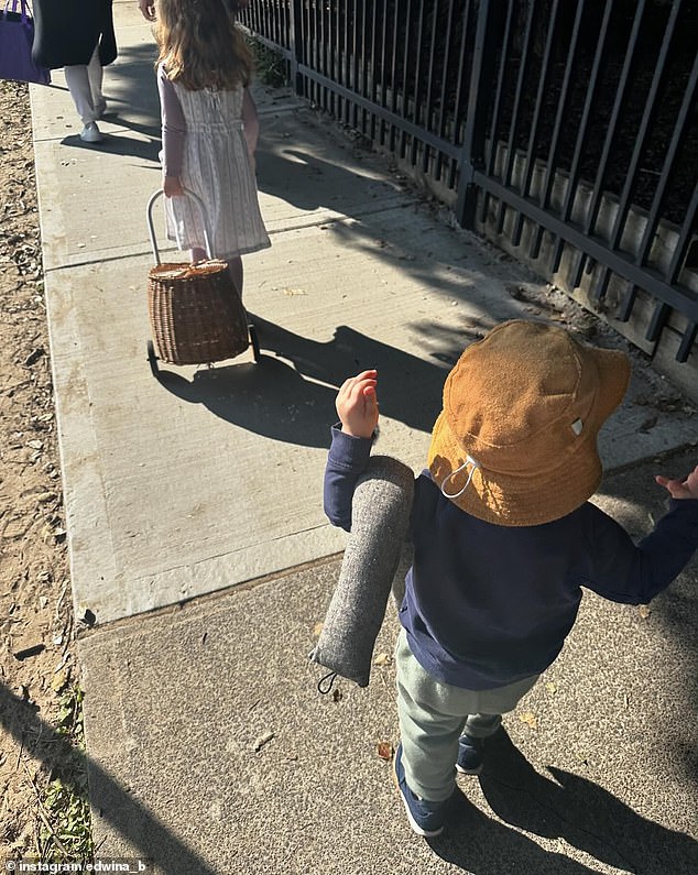 Alongside a photo of her two-year-old son Tom holding a draught excluder with a 'door snake' as he walks to a local park, Edwina wrote some heartfelt words