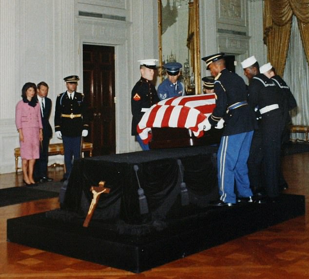 Jackie and Bobby Kennedy watch as JFK's casket arrives in the East Room of the White House after his assassination.