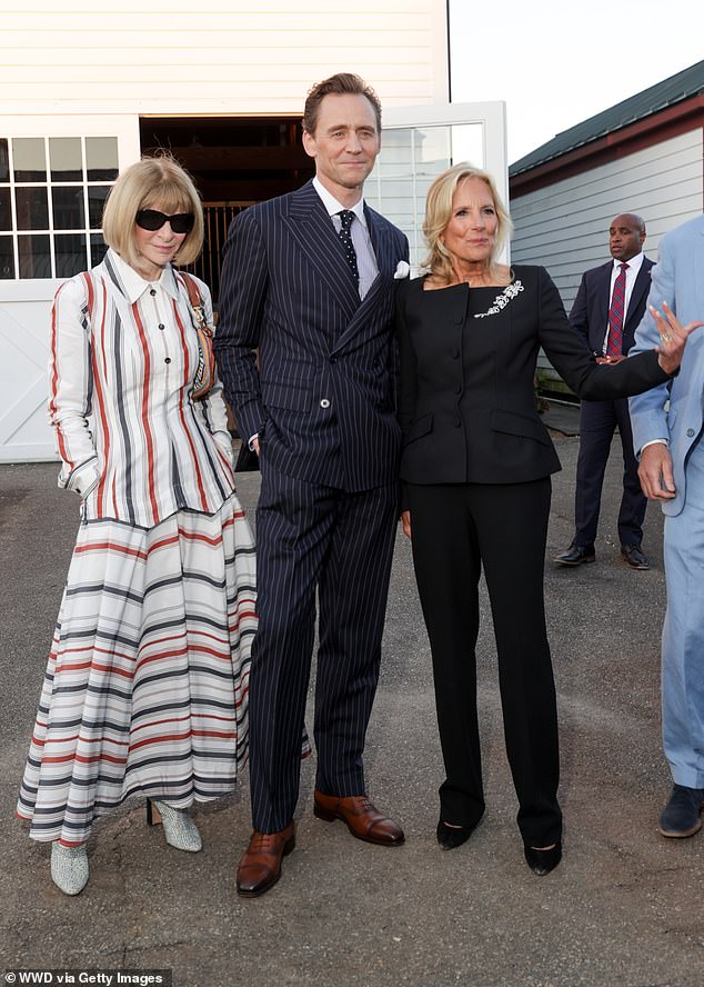 Vogue editor-in-chief Anna Wintour added a pop of color when she wore a striking rust-colored, blue-and-white striped shirt dress, paired with her signature sunglasses (pictured with Tom and Dr. Jill Biden)