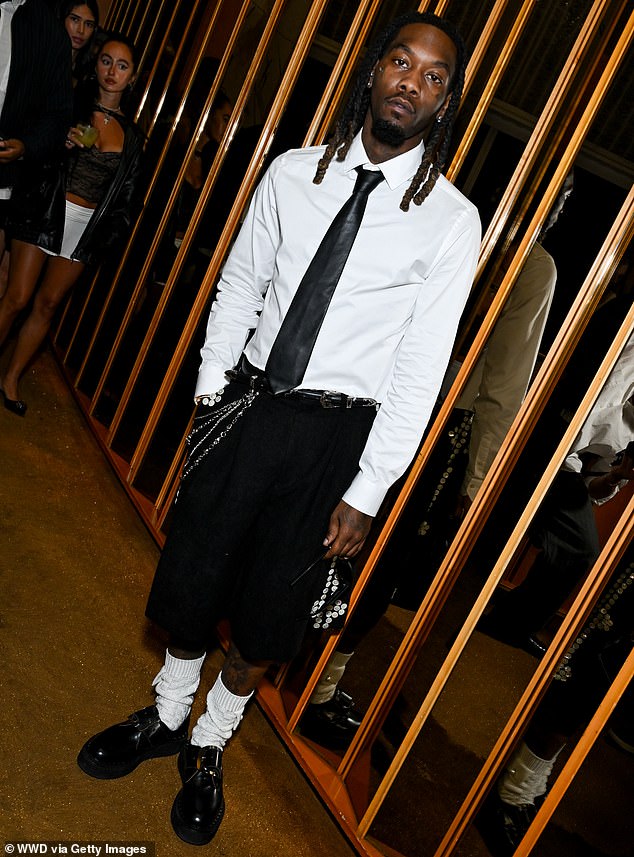 The 32-year-old American rapper Offset wore a white long-sleeved shirt with a black tie, and long black shorts with silver chains over one of the pockets.