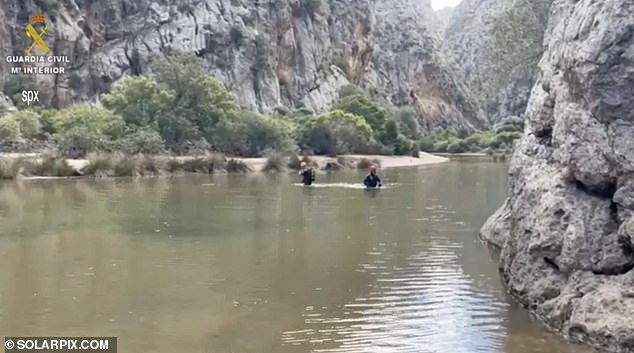 The grim discovery was made yesterday after divers joined the search for the missing 32-year-old, who was swept away by the floodwaters as he tried to rescue his girlfriend (Picture: Search teams wade through the water)