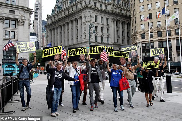 Protesters holding up signs reading 