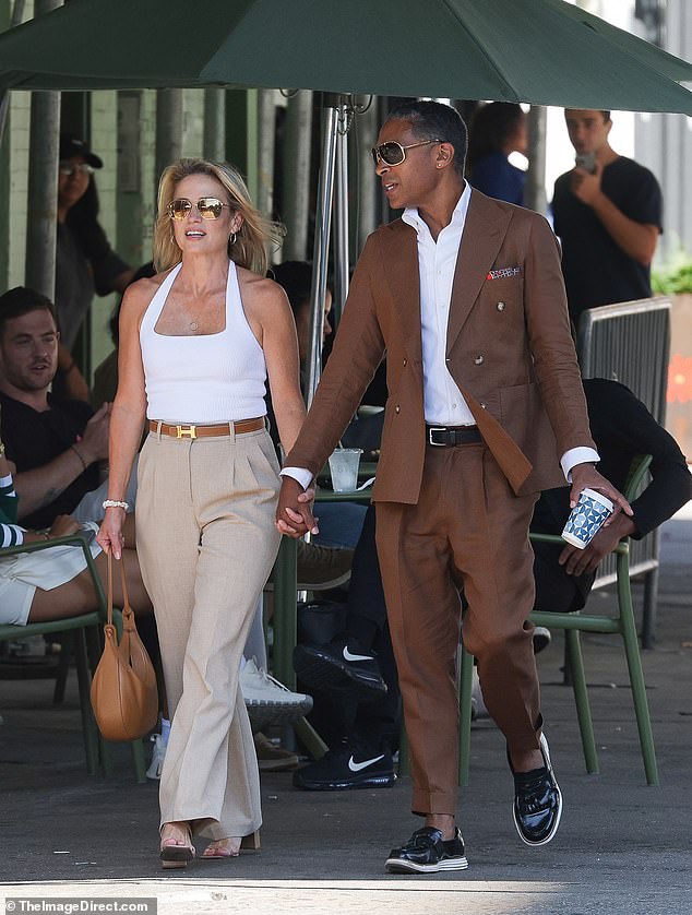 Amy dressed in a white halter top, beige pants, a brown Hermes belt and heels, matching TJ's brown suit