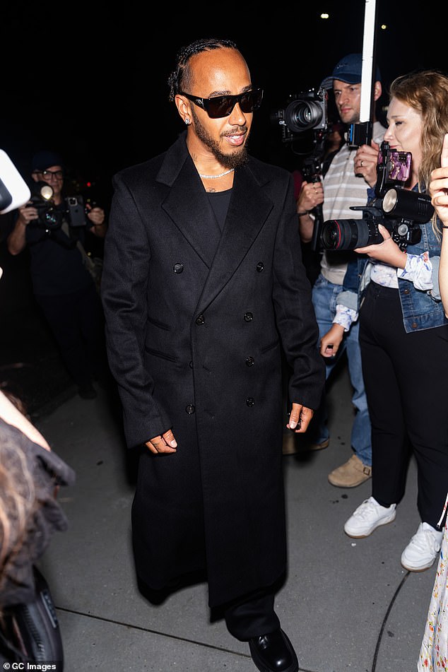 Racing driver Lewis Hamilton, 39, wore a Matrix-style look, with a long black coat and black sunglasses