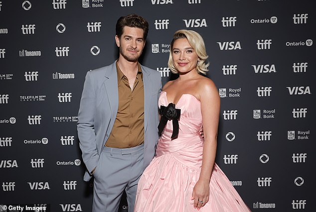 Garfield, looking sharp in a light gray suit paired with a brown shirt, kept it classy as he posed with his arm around Florence, making a striking duo for the cameras