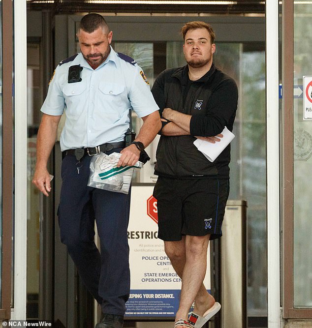 Gulson is escorted out of Surry Hills police station by a police officer on Saturday