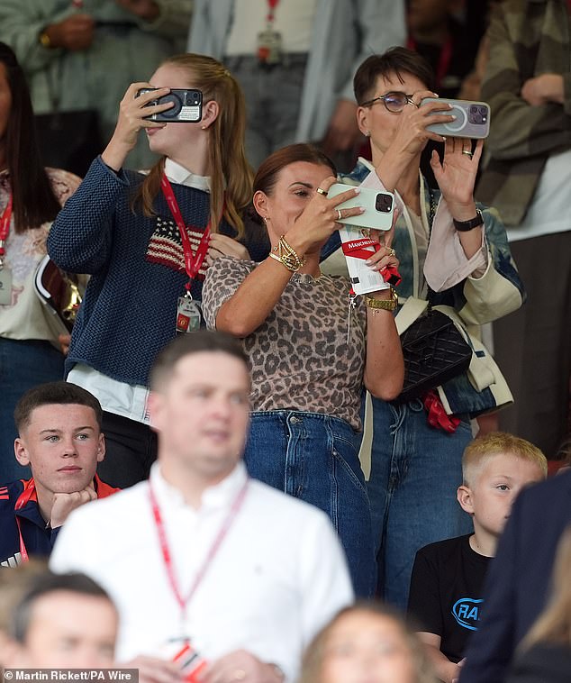 The beauty accessorised her look with a layer of gold bracelets and earrings as she enthusiastically filmed and snapped Wayne during the match