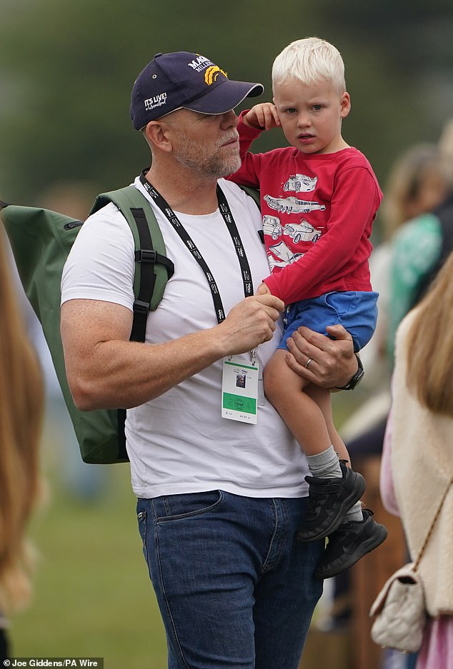 Mike, 45, was photographed carrying his youngest child through the grounds, before his six-year-old daughter clung to his arm as he was lifted inches off the grass