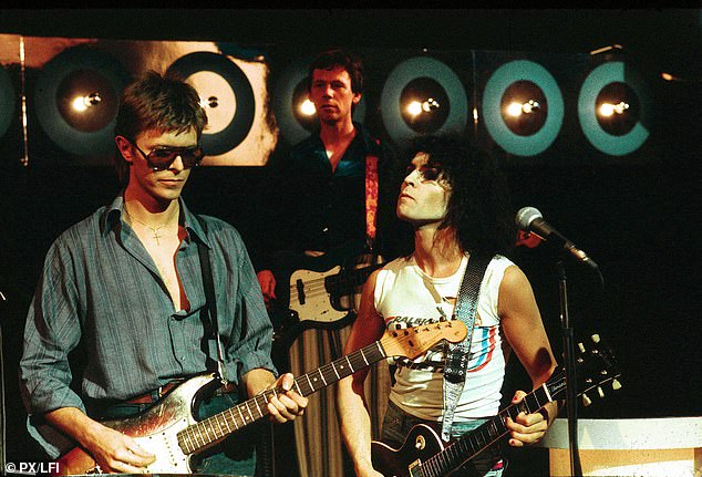 Flowers appears in the background as he plays alongside legends David Bowie and Marc Bolan