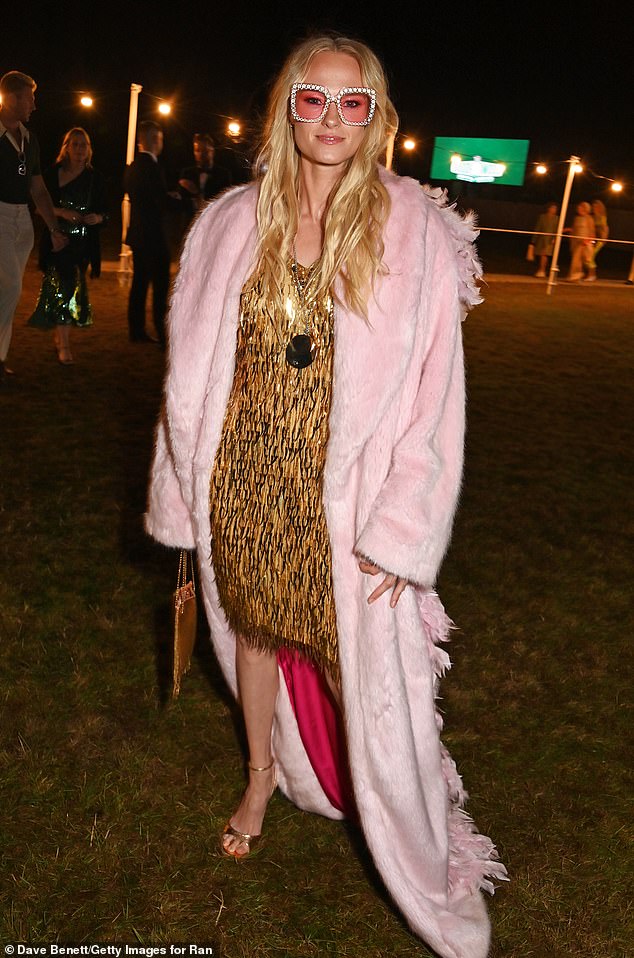 The actress wore a mini dress with gold tassels, paired with a pink faux fur coat and pink printed sunglasses