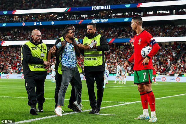 The invader was helplessly happy with Ronaldo as he was led away by three stewards