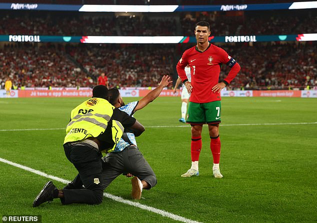 Matchwinner Ronaldo watches with disdain as pitch invader begs him for a selfie