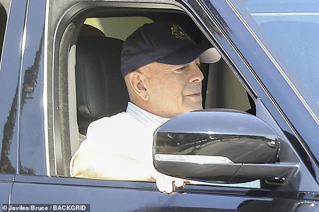 The Pulp Fiction actor was sitting in the passenger seat of a vehicle, wearing a black cap and a collared shirt with horizontal gray stripes