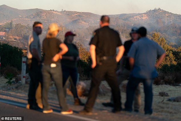 Police officers hold a conversation as the Boyles Fire rages in Clearlake, California