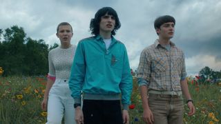 Eleven, Mike and Will stare into the distance from a hill in Stranger Things season 4