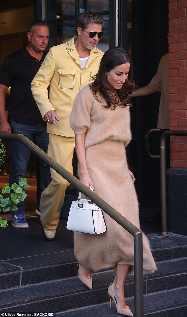 At one point he held hands with his 34-year-old lady, who was dressed in a textured brown skirt and matching nude suede high heels