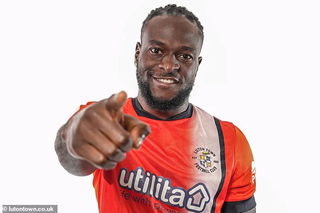 Victor Moses poses in Luton's home shirt after joining the club on a free transfer