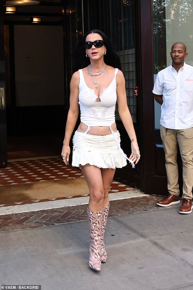 Katy paired the fitted top and pleated mini skirt with snakeskin boots and layers of necklaces