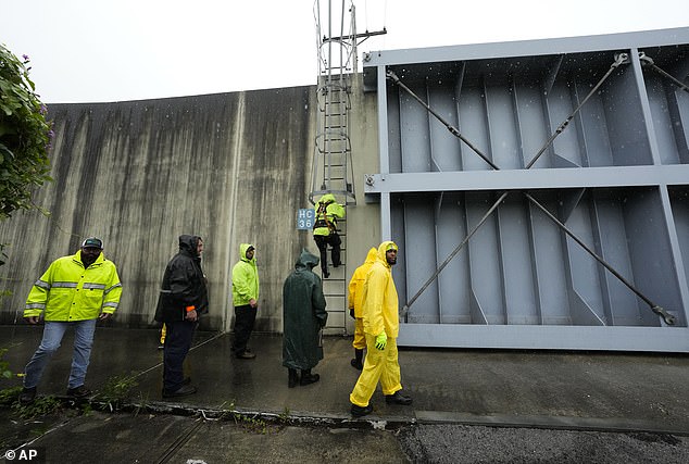 Workers with the Southeast Louisiana Flood Protection Authority-West close floodgates along the Harvey Canal, just outside the New Orleans city limits, in anticipation of Tropical Storm Francine, in Harvey, Louisiana on Tuesday.