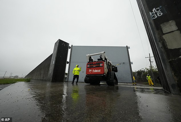 Workers with the Southeast Louisiana Flood Protection Authority-West close floodgates along the Harvey Canal, just outside the New Orleans city limits, in anticipation of Tropical Storm Francine, in Harvey, Louisiana on Tuesday.