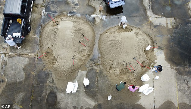 Residents of St. Bernard Parish fill sandbags at a Kmart and Sears parking lot in Chalmette, Louisiana, on Monday in preparation for Tropical Storm Francine