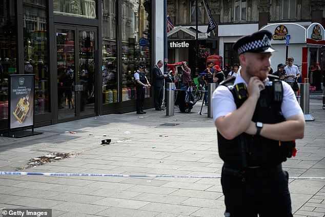 A police officer stands at a cordoned off area following a double stabbing in Leicester Square on August 12, 2024